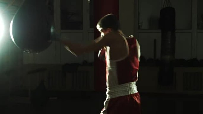 年轻拳击手在健身房打出气筒的剪影