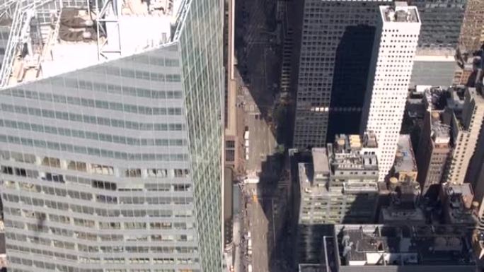 空中特写: 沿着纽约第六大道在玻璃状摩天大楼上方飞行