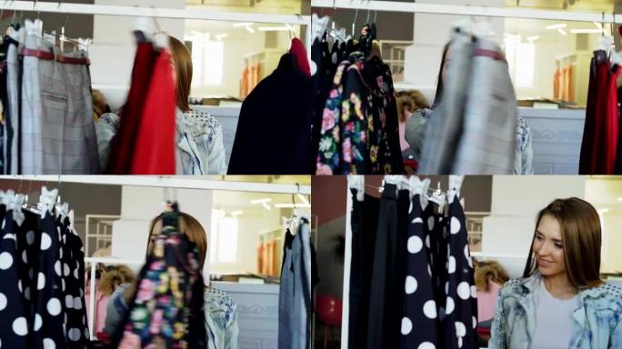 年轻女士购物的特写镜头，在铁轨上浏览五颜六色的衣服，触摸和移动它们。前台的时尚女装。