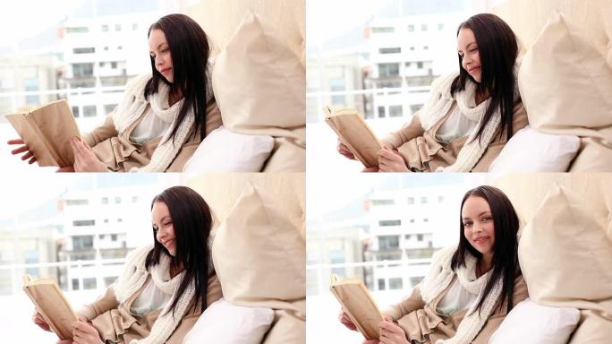 漂亮的黑发女人在床上看书