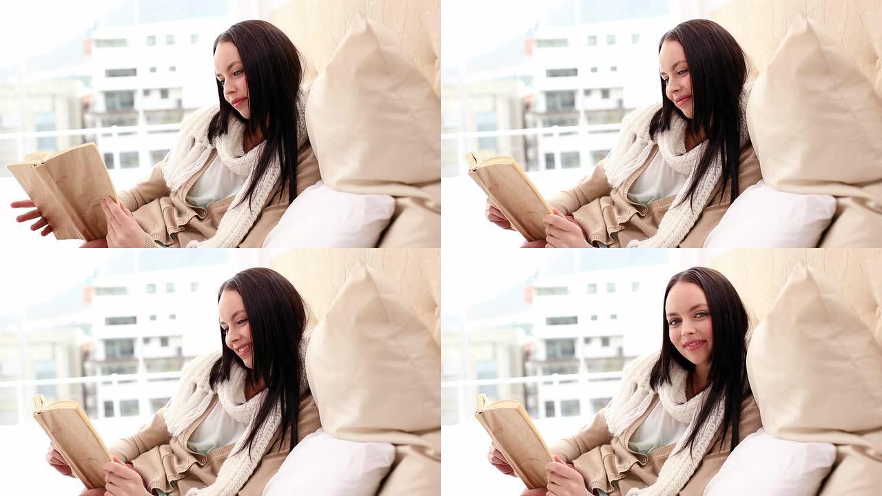 漂亮的黑发女人在床上看书