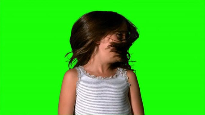 小女孩在绿色屏幕上摇晃头发