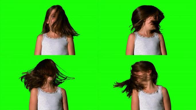 小女孩在绿色屏幕上摇晃头发