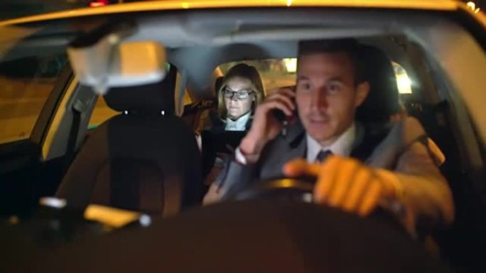 WS司机在豪华轿车后座上开车时打电话给女商人