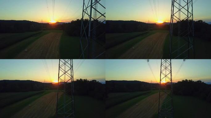 空中: 金色日出时农业用地和电塔上的干草堆