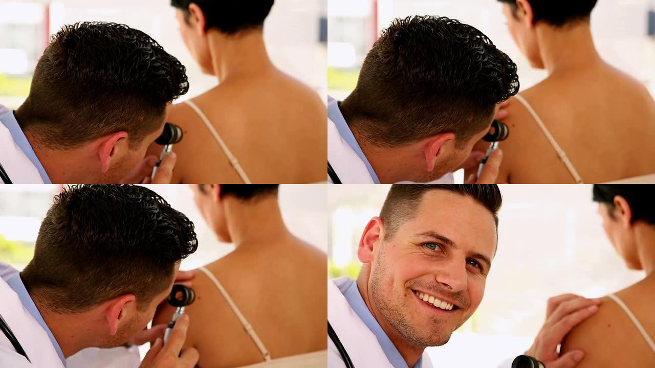 皮肤科医生检查妇女的背部并在镜头前微笑