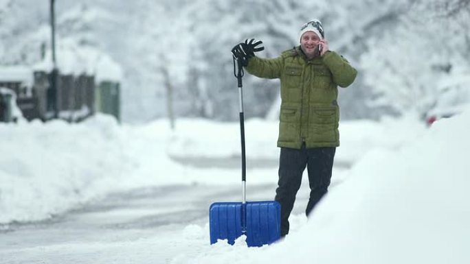 高清: 男子在铲雪时打电话