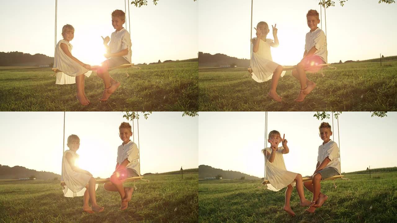慢动作开朗的男孩和女孩坐在日落时摆姿势拍照