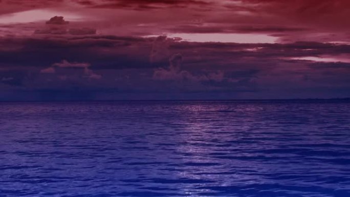 在蓝紫色的海洋上，美丽而令人印象深刻的红色日落
