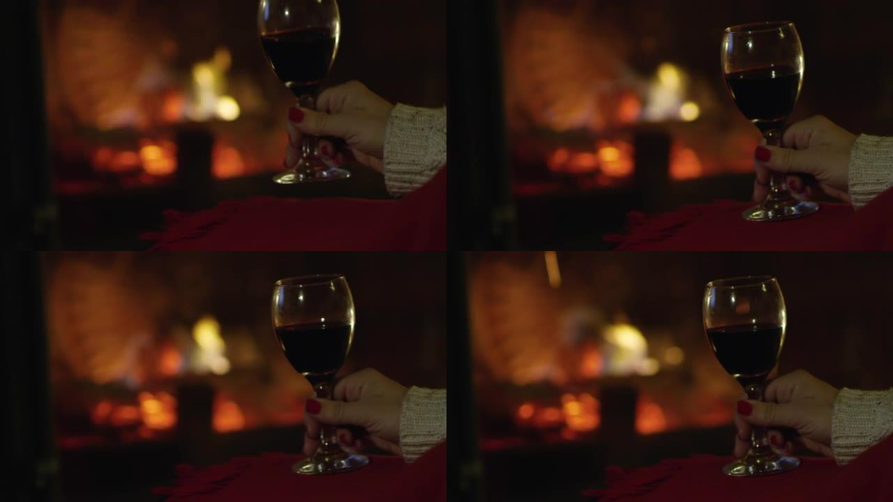 4k特写女人放松，在舒适的壁炉旁喝红酒，慢动作