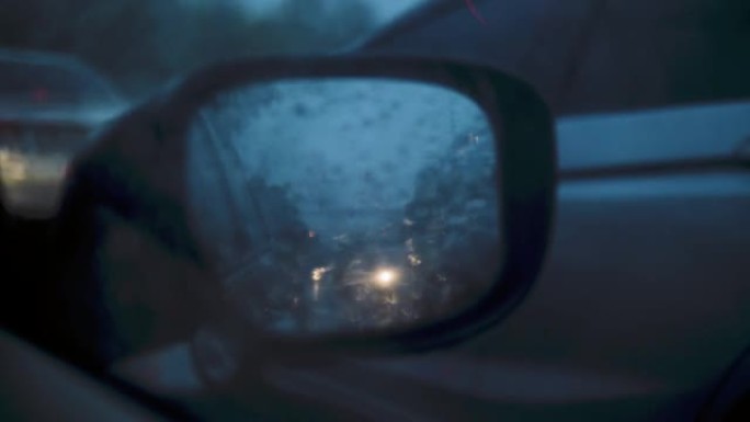 汽车侧镜在雨中，而交通堵塞