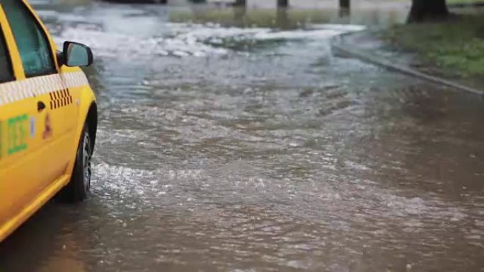 雨水倾泻在人行道上，出租车变成洪水