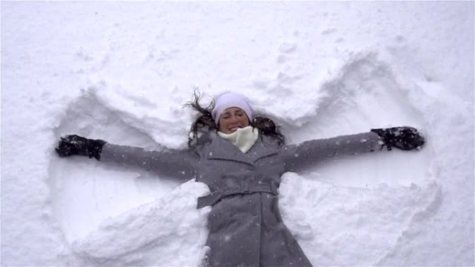 慢动作: 年轻女子制作雪天使