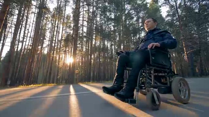 一个残疾人正坐在电动轮椅上沿着道路行进