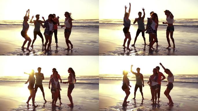 日落时在海滩上跳舞的朋友
