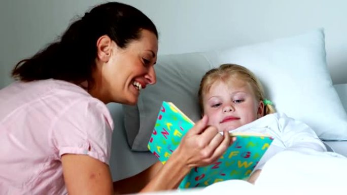 床上的女孩和她的母亲一起看书