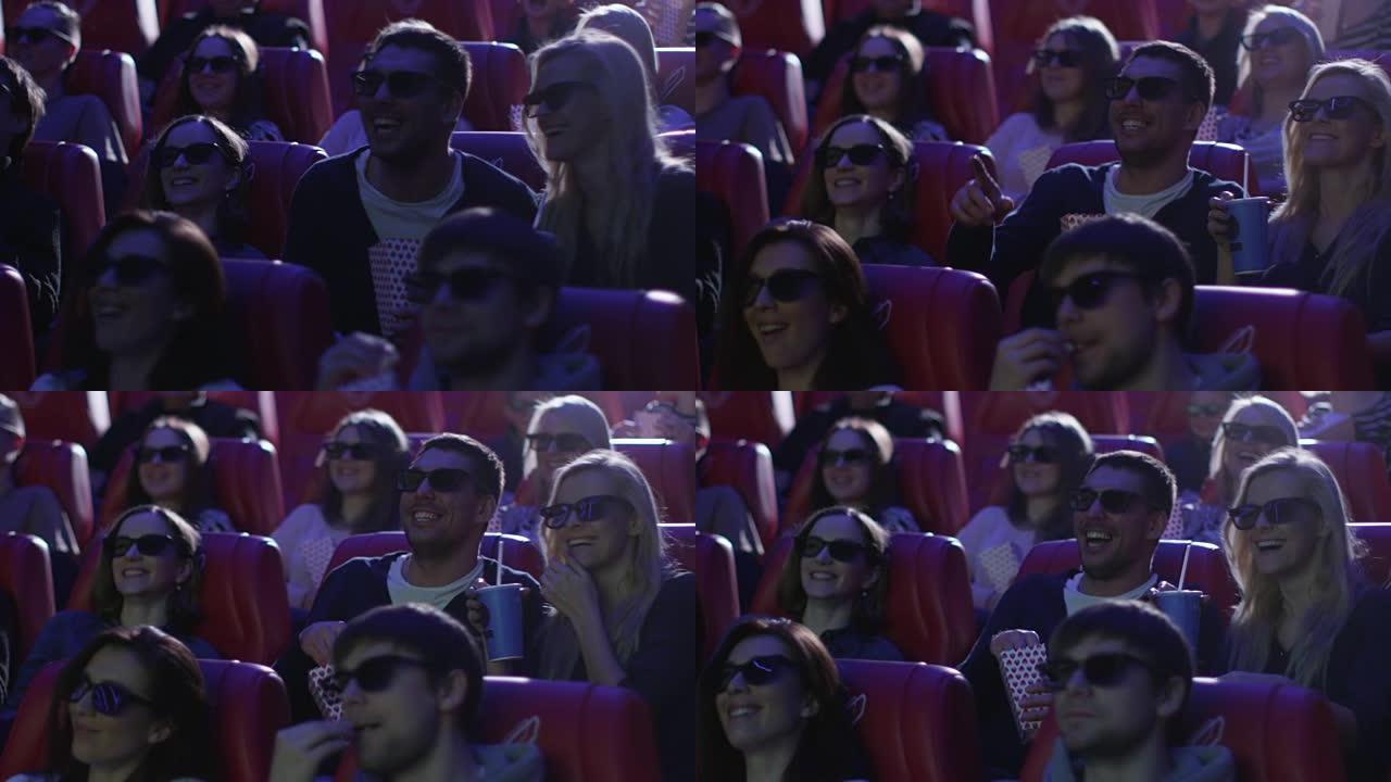 一群戴着3d眼镜的人在电影院看喜剧电影放映时大笑。