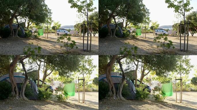 阳光明媚的夏季露营地的帐篷和汽车