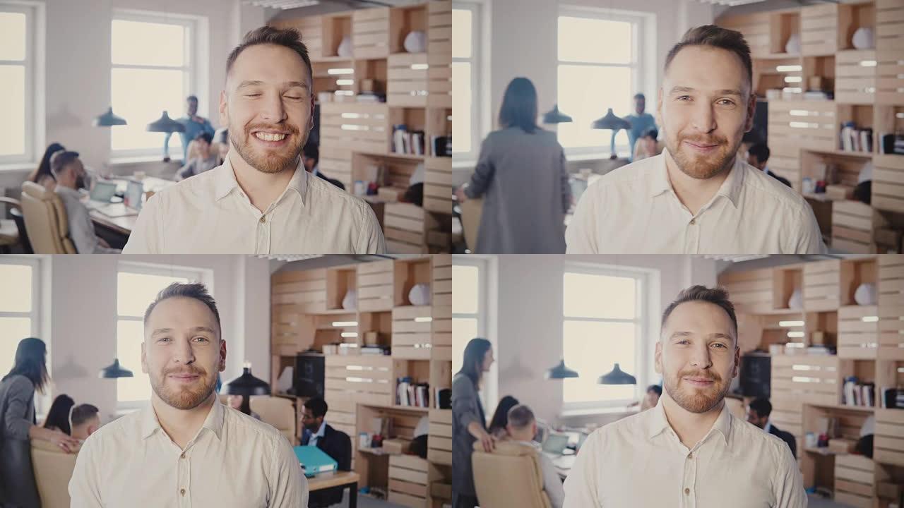 在现代时尚的办公室里，成功的白人商人微笑着看着镜头，人们在4K背景下工作