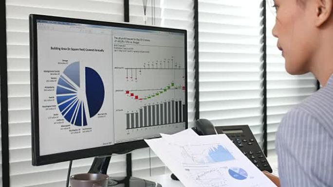 女商人在计算机上查看图表以分析业务项目