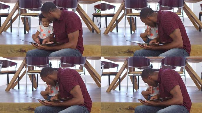父亲在一起阅读故事时亲吻年幼的女儿的脚趾