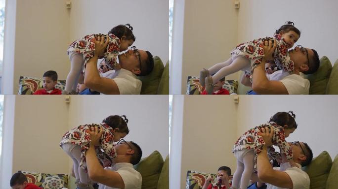 西班牙裔父亲在亲吻女婴时将女婴抱在空中