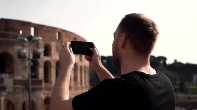 英俊的游客参观意大利罗马，为罗马斗兽场拍照。背景是游客的风景。慢动作