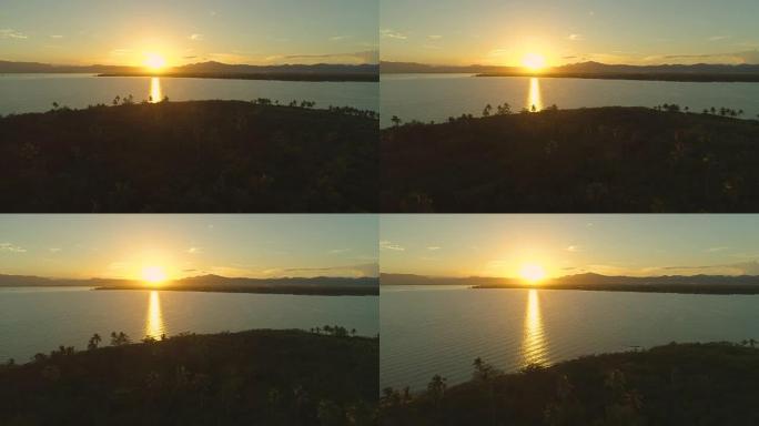空中: 五颜六色的燃烧橙色日落在宁静的天堂岛上闪耀。