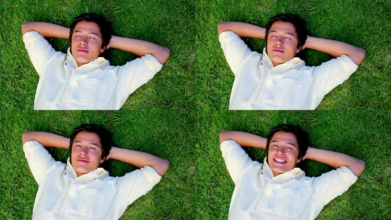 微笑的人躺在草地上