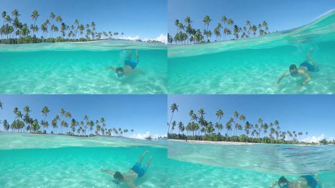 4k慢动作水下特写: 快乐的年轻潜水员暑假在热带岛屿前的水晶般清澈的泻湖海洋中浮潜，充满异国情调的沙