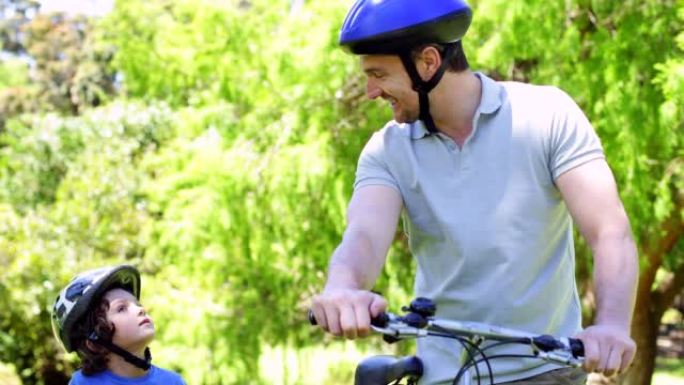 父亲和年幼的儿子在公园骑自行车