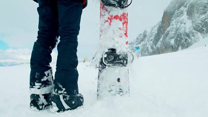 SLO MO滑雪板手在雪地里粘了他的木板