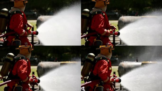 消防员使用灭火器和水管中的水进行消防。在危险情况下，消防员穿着消防服以确保安全。