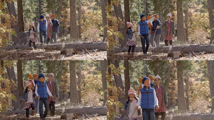 亚洲五口之家在森林里散步，孩子们指指点点