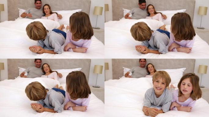 可爱的父母和孩子躺在床上聊天