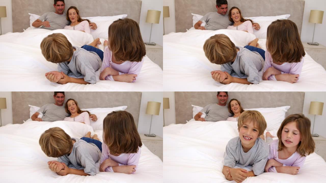 可爱的父母和孩子躺在床上聊天