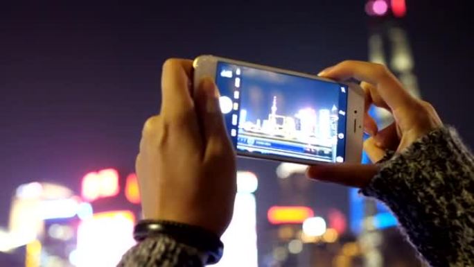 年轻的亚洲妇女在现代城市玩手机