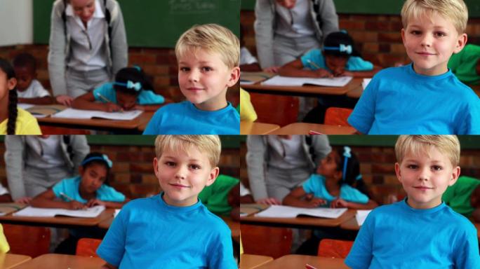 小男孩在上课时对着镜头微笑