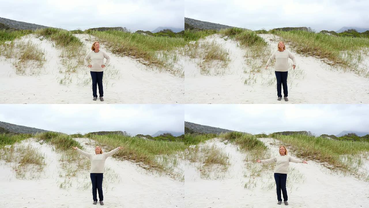 快乐的退休女人站在沙滩上