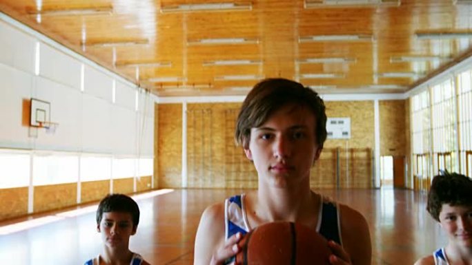 在篮球场上拿着篮球的男生肖像
