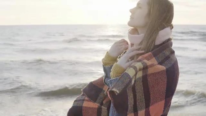 年轻体贴的女人站在海边欣赏风景的肖像。女性做头发和做梦