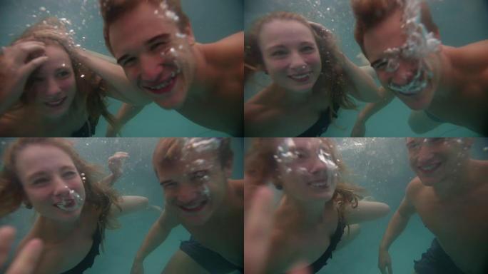 夫妇在游泳池水下游泳时微笑