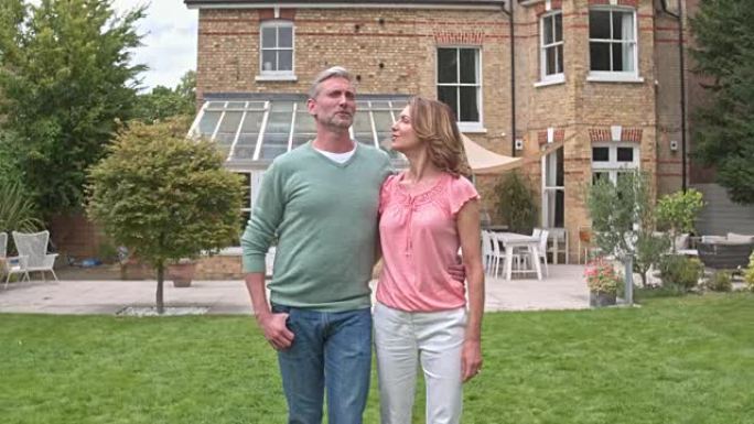 成熟的夫妇在新房子的后花园散步的实时视频