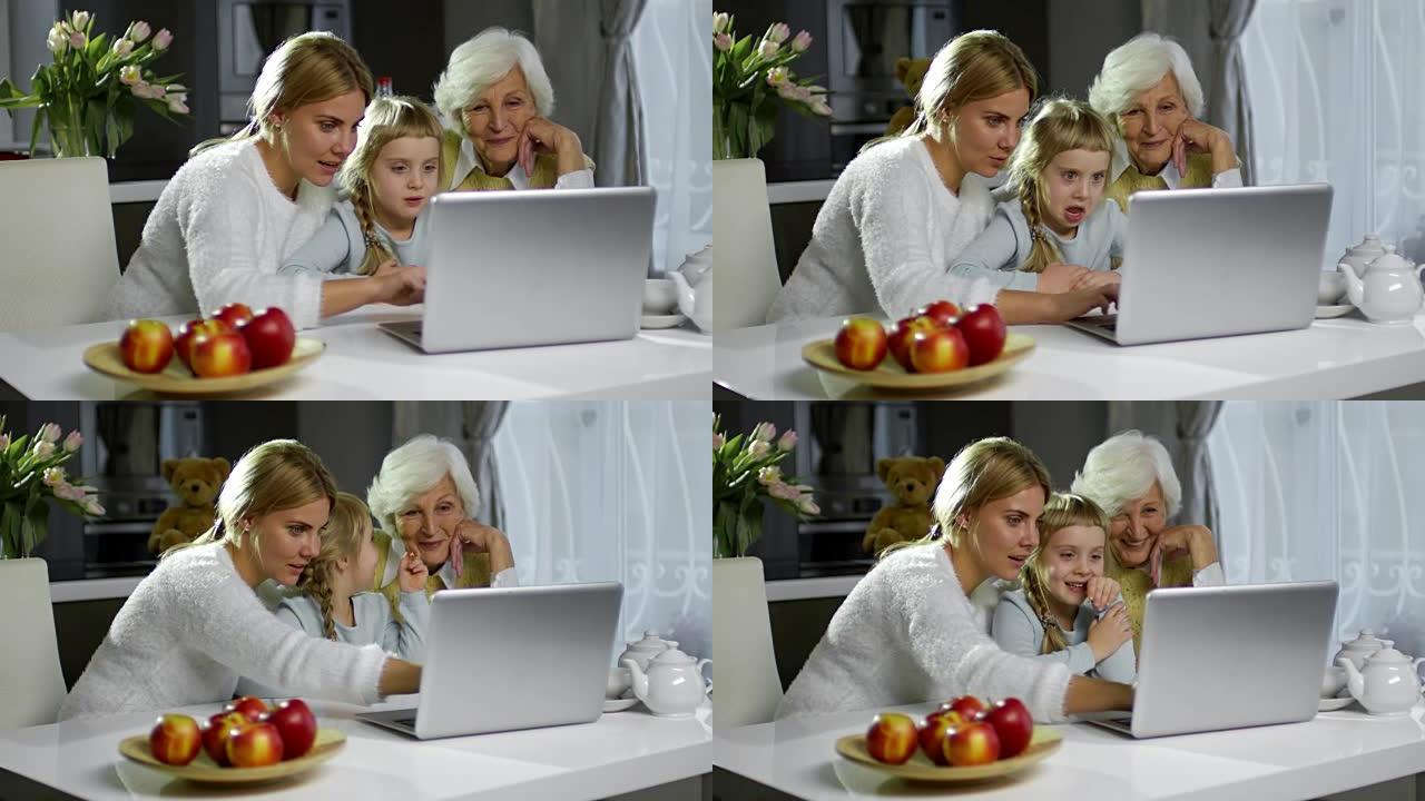 可爱的妈妈和奶奶用笔记本电脑和女孩在一起