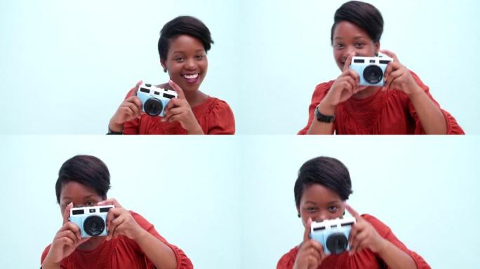 幼稚的年轻非洲妇女用老式相机拍照