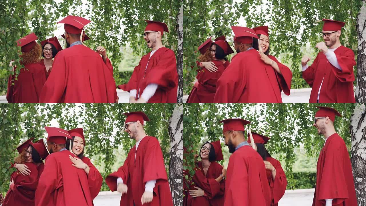 穿着长袍和帽子的快乐男孩和女孩毕业生互相拥抱祝贺毕业，欢笑和娱乐。高等教育和成功理念。