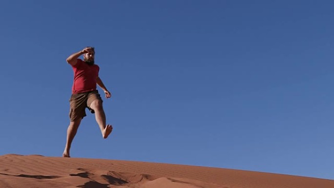 男子在纳米布-瑙克鲁夫特国家公园内的沙丘表面奔跑和跳跃的慢动作
