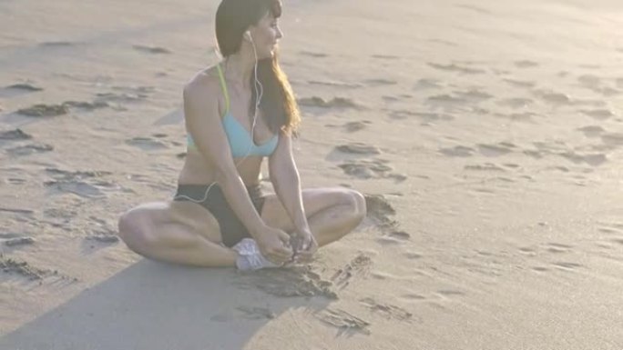 微笑的女人在海滩上做瑜伽