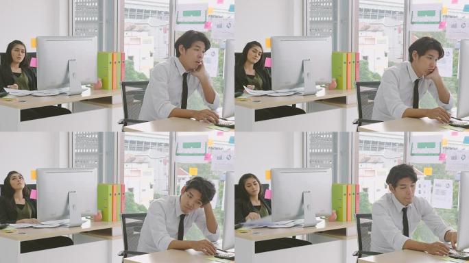 年轻的亚洲同事在办公室感到无聊