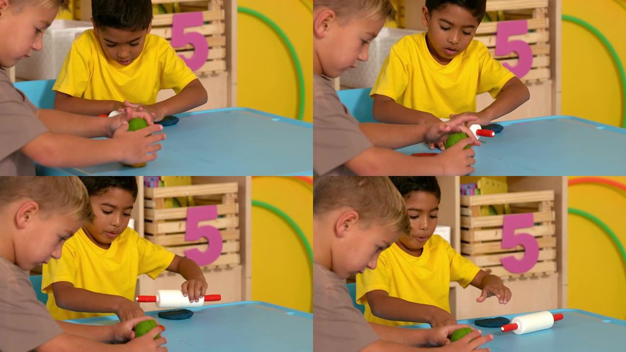 可爱的小男孩在教室里玩模型粘土
